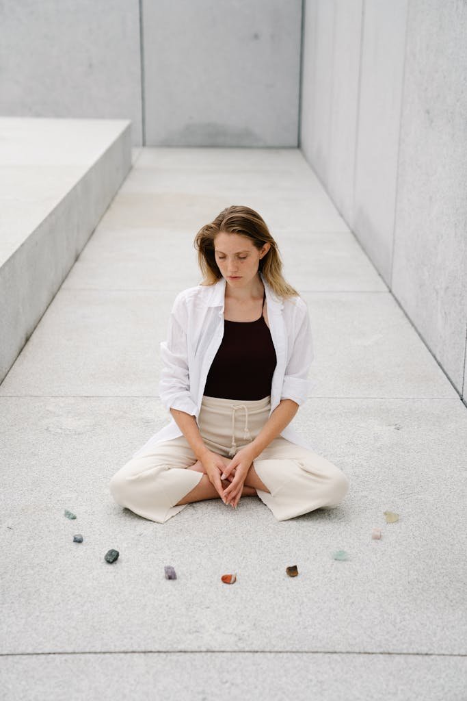 A woman practices meditation with crystals in a serene outdoor setting, promoting tranquility and mindfulness.