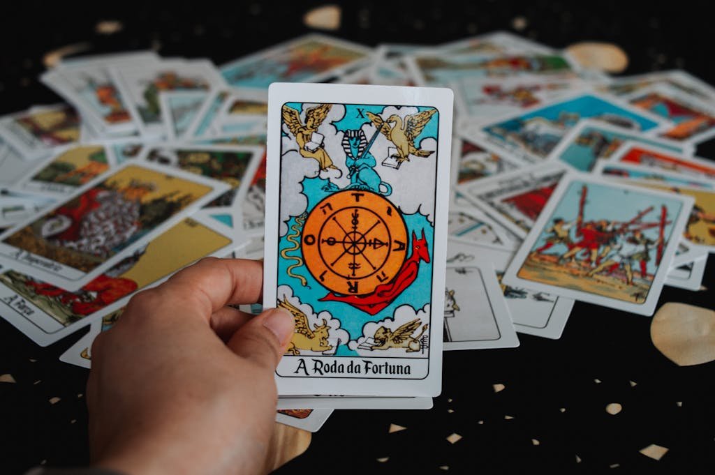 Close-up of a hand holding a tarot card in a deck for a fortune-telling session.